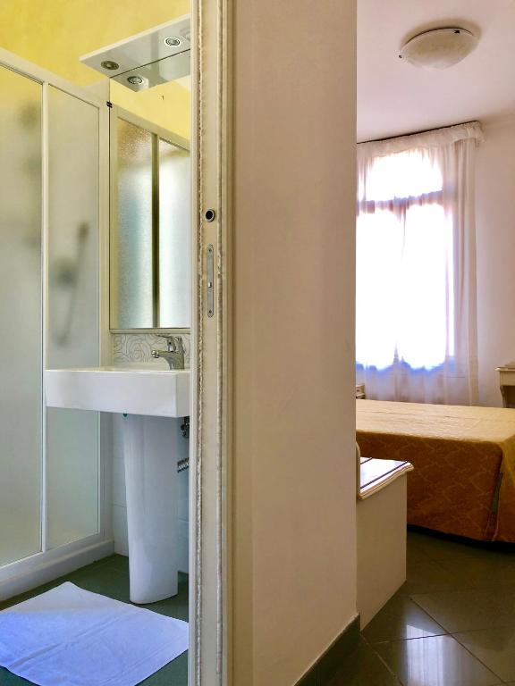a bathroom with a sink and a mirror and a bed at Hotel Marte in Venice