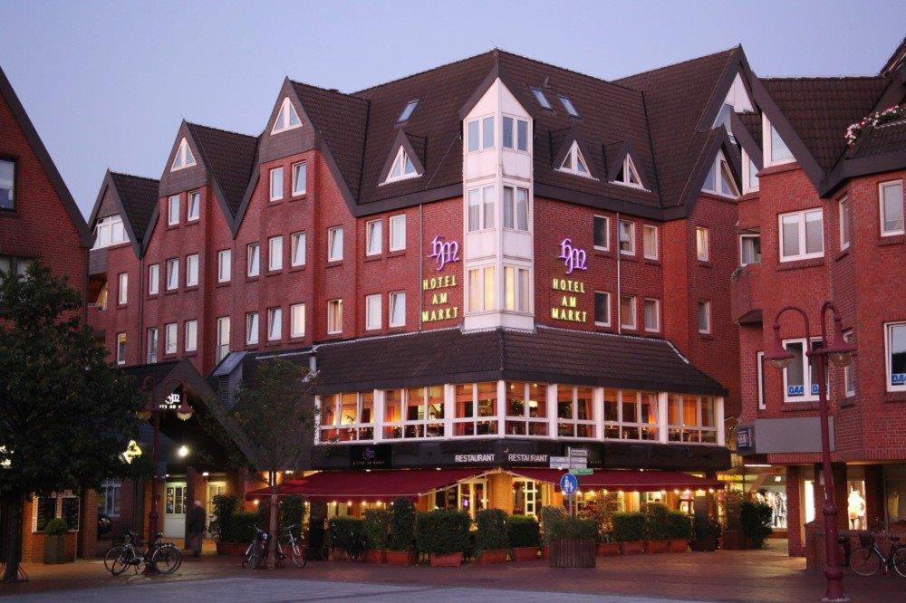 ein großes rotes Gebäude mit schwarzem Dach in der Unterkunft Hotel Am Markt Nordenham in Nordenham