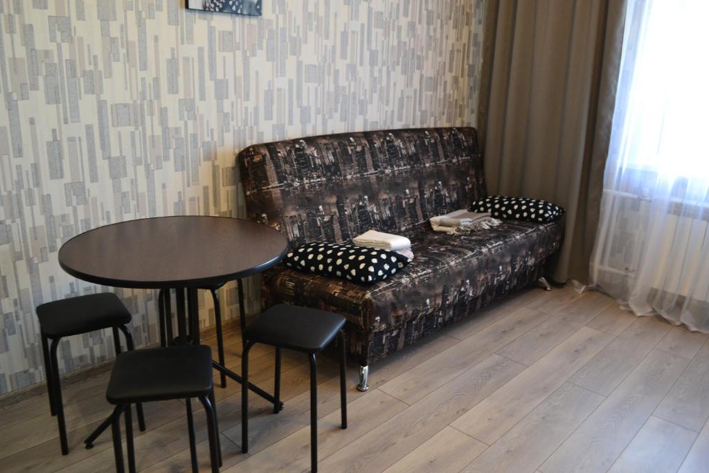 ノヴォシビルスクにあるАпартаменты на Немировича-Данченкоのリビングルーム(ソファ、テーブル、椅子付)