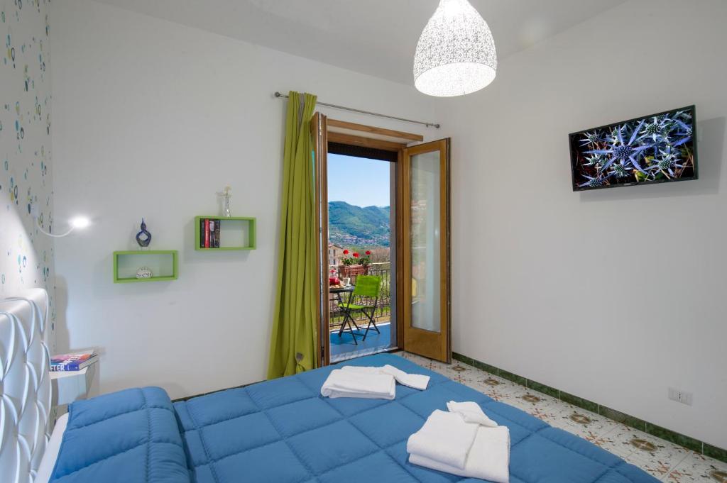 een woonkamer met een blauwe bank en een raam bij Casa Loreto, Agerola in Agerola
