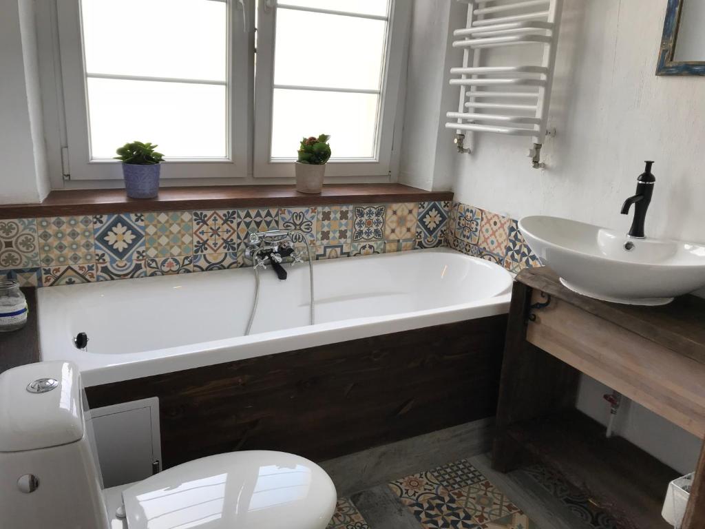 a bathroom with a tub and a sink and a toilet at Apartament Do Zobaczenia Olsztyn in Olsztyn