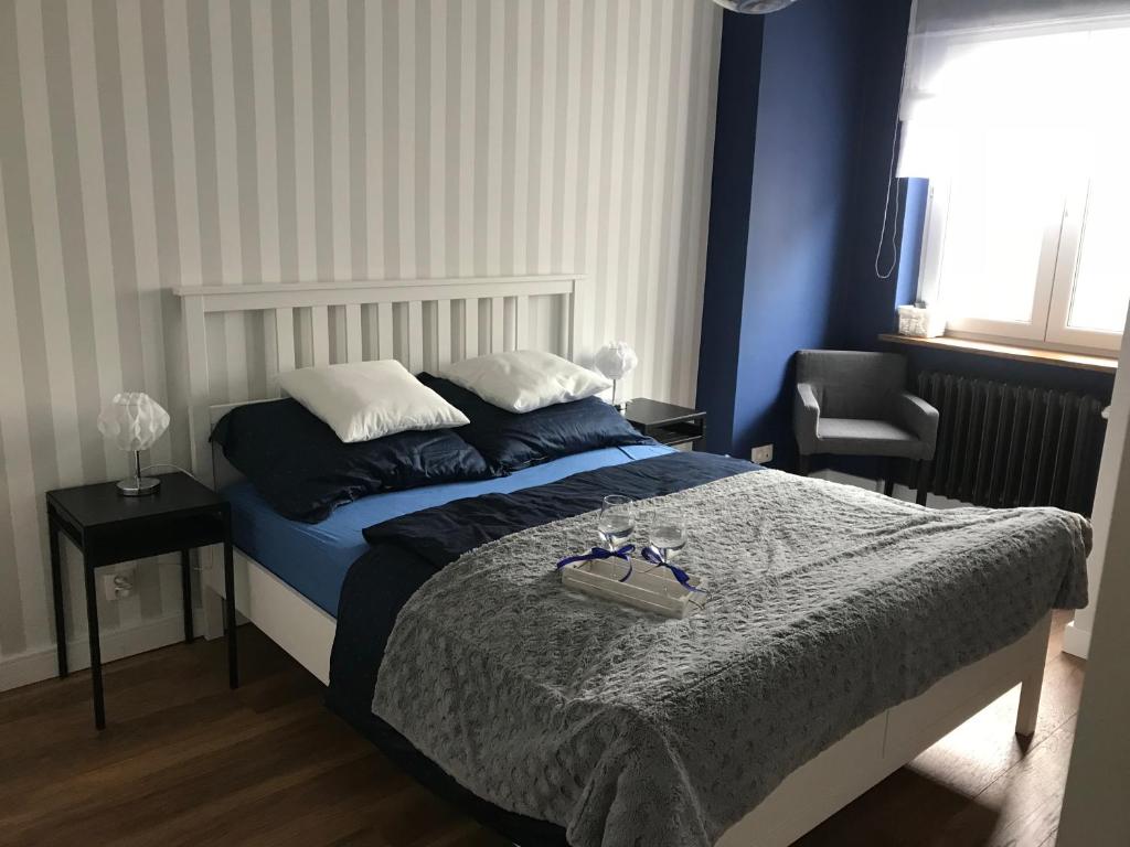 - une chambre avec un lit bleu et blanc dans l'établissement Apartament 27, à Gdynia