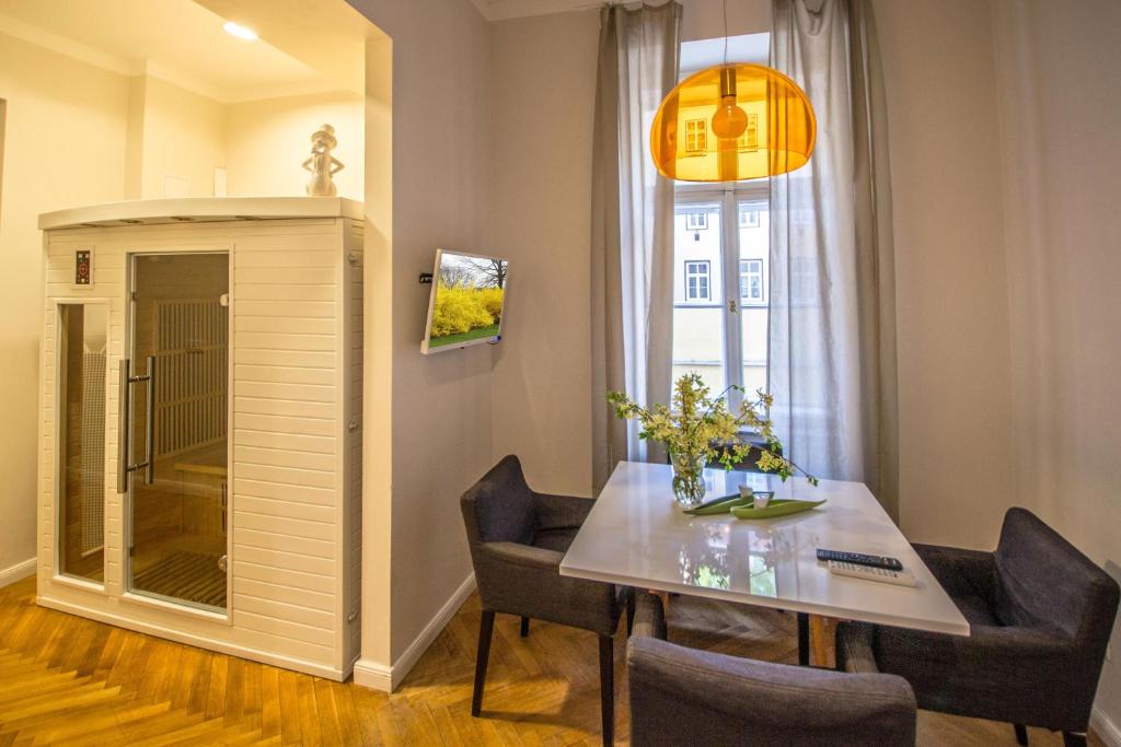 ein Esszimmer mit einem Tisch, Stühlen und einem Fenster in der Unterkunft Vojtesska Apartment By Ruterra in Prag