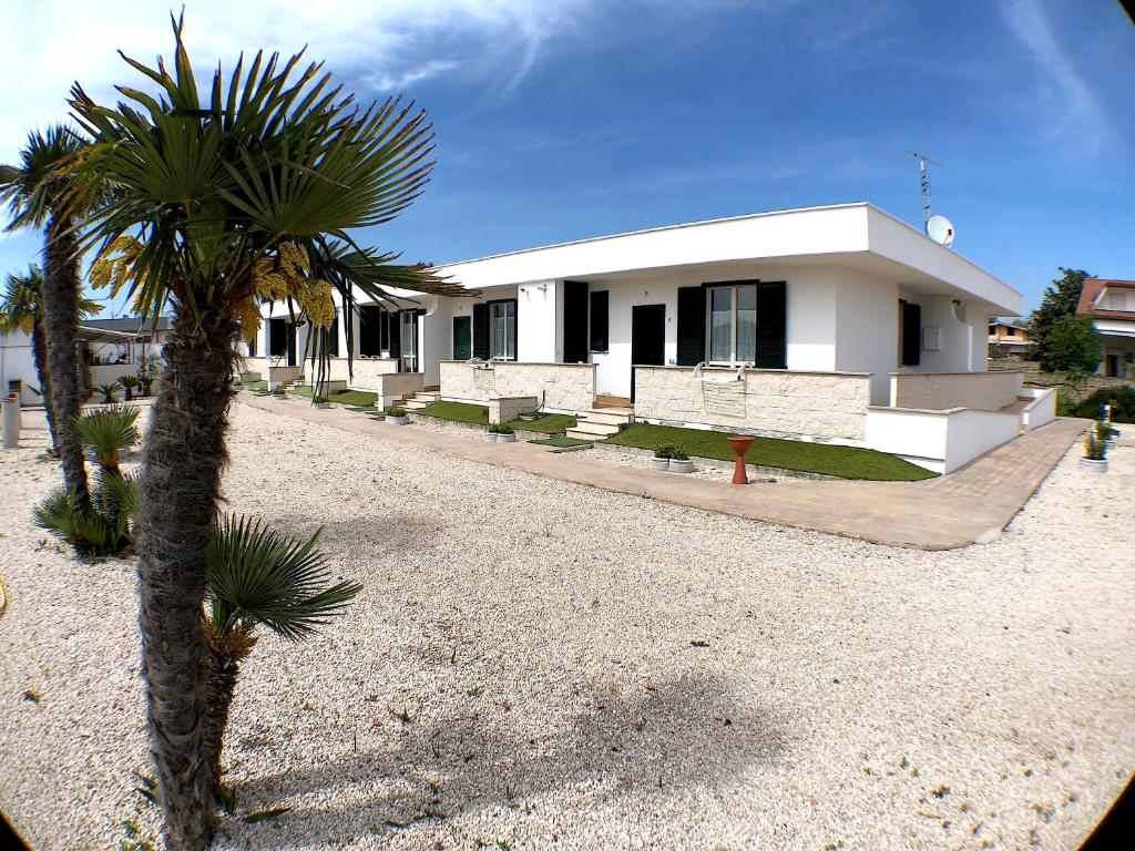 une maison avec un palmier en face dans l'établissement Residence Pegaso, à Nettuno