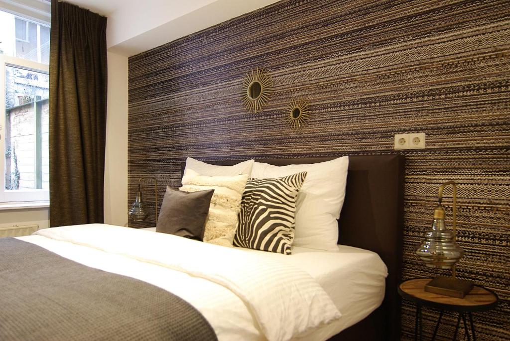 een slaapkamer met een groot bed met een houten hoofdeinde bij Luxury Leidseplein with Private Patio in Amsterdam