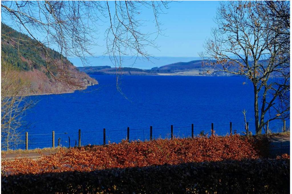 um grande lago azul com uma cerca em frente em Urquhart Bay B&B em Drumnadrochit