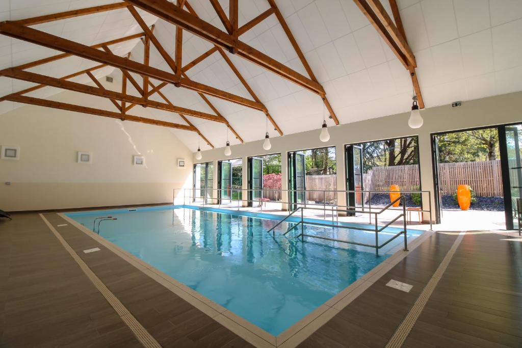 a large indoor swimming pool with blue water at Loire & Sens in Juigné-sur-Loire