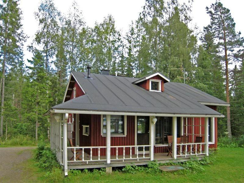 a red house with a black roof at Haapaniemi Cottages in Iisalmi