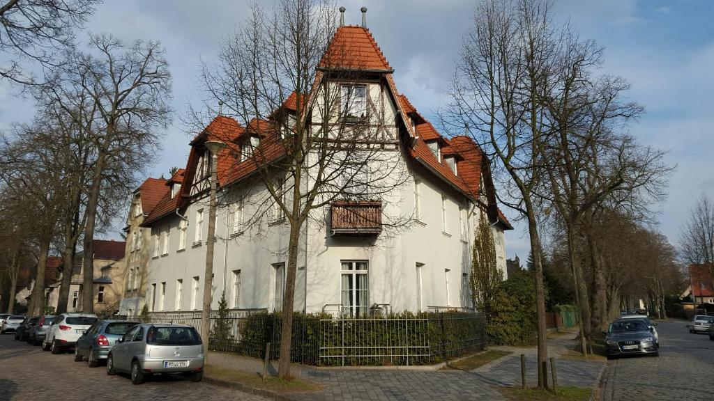 una gran casa blanca con techo de gambrel en Ferienwohnung Babelsberg en Potsdam