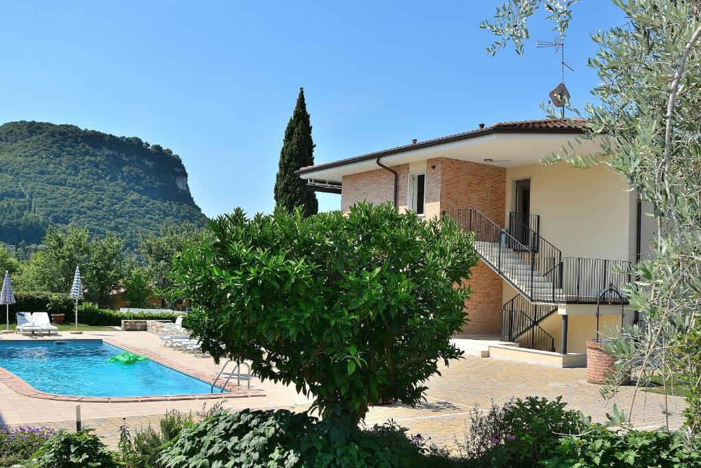 a villa with a swimming pool in front of a house at Cà Gardesana With Pool in Garda