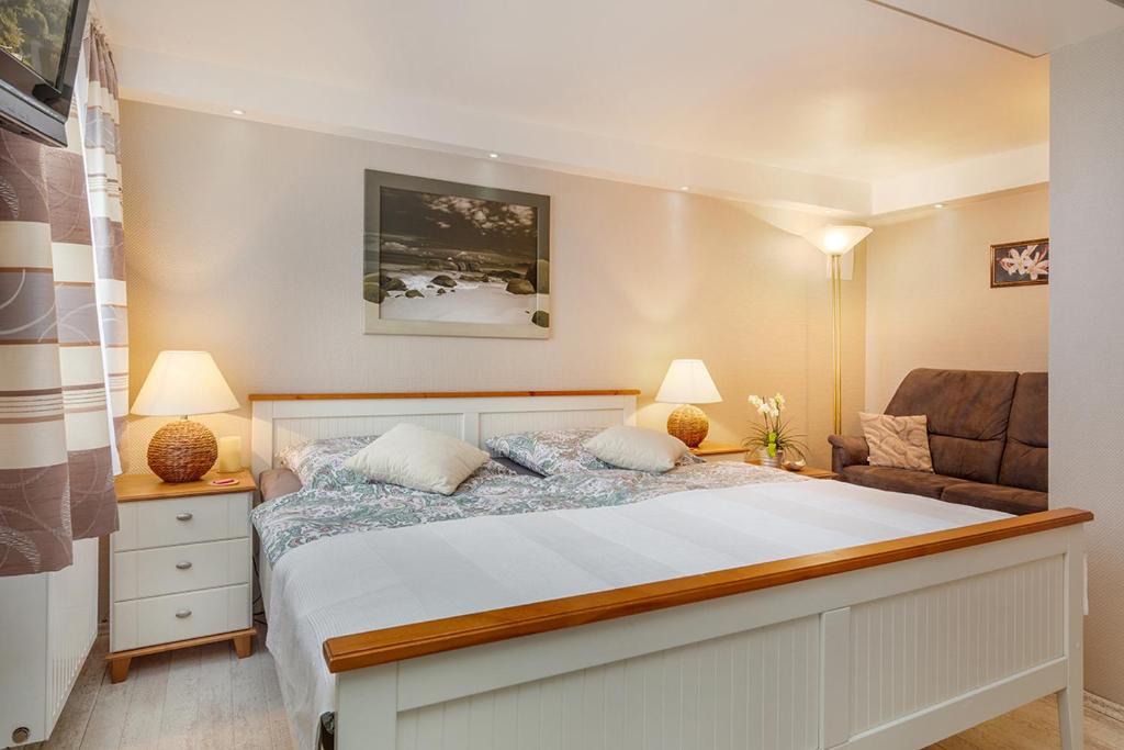 ein Schlafzimmer mit einem großen Bett und einer Couch in der Unterkunft Apartment Charlotte in Zirkow