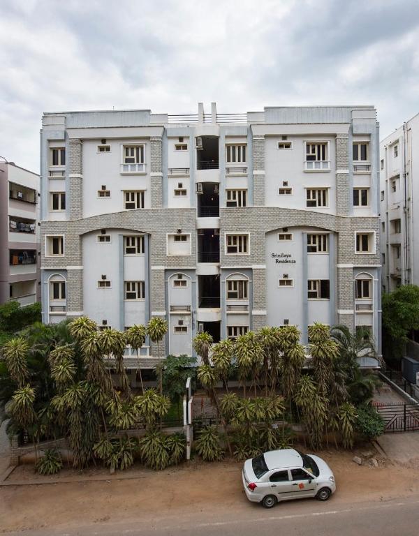 a car parked in front of a large building at Hotel Athome & Serviced Apartments by Deccan Serai Hotels in Hyderabad