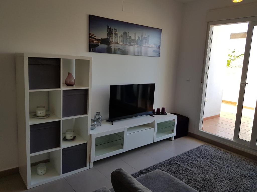 a living room with a television on a white entertainment center at Las Terrazas De La Torre Apartment in Roldán