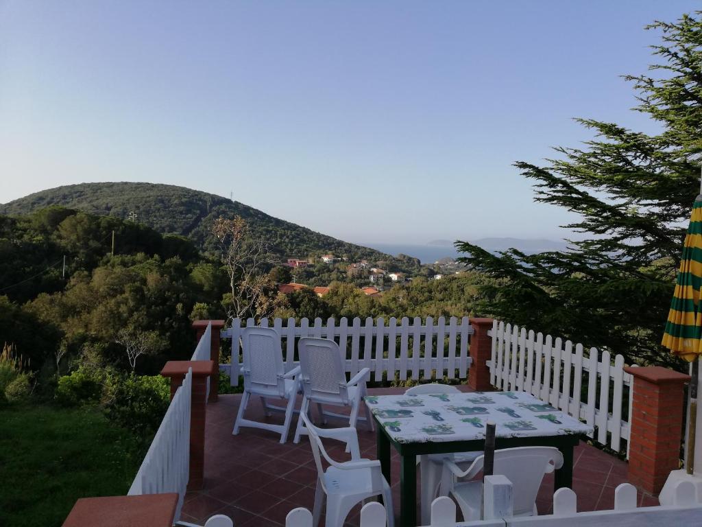 a patio with a table and chairs on a white fence at Appartamento Cavo in Cavo