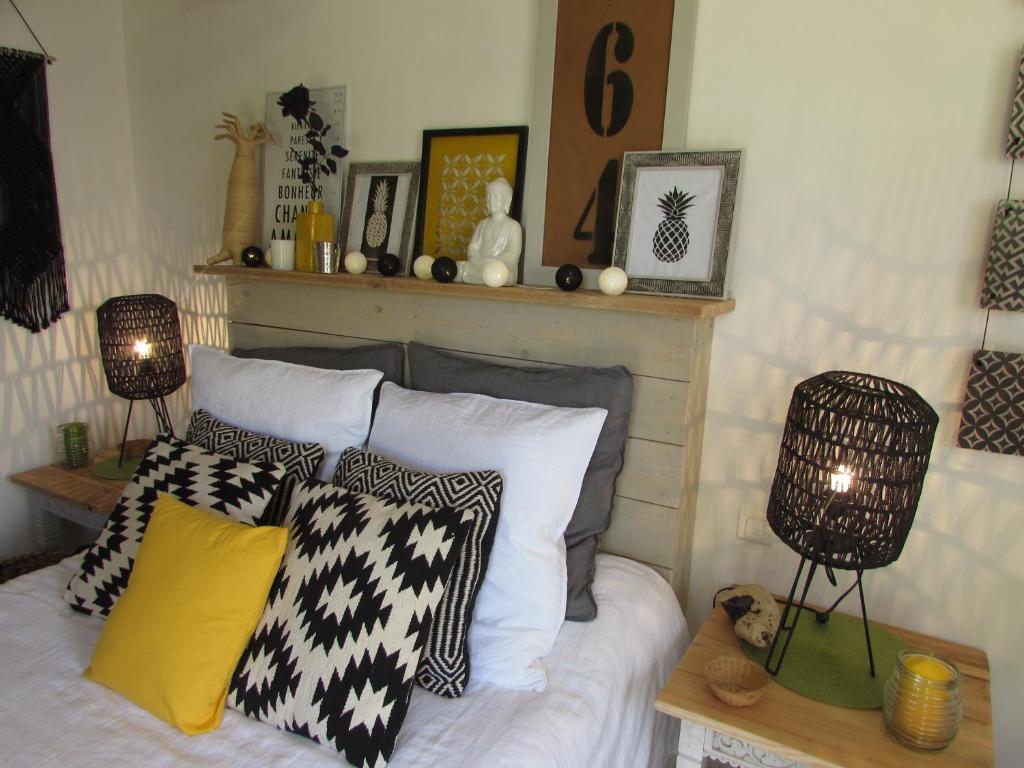 um quarto com uma cama com almofadas pretas e brancas em La Joliette em Junas