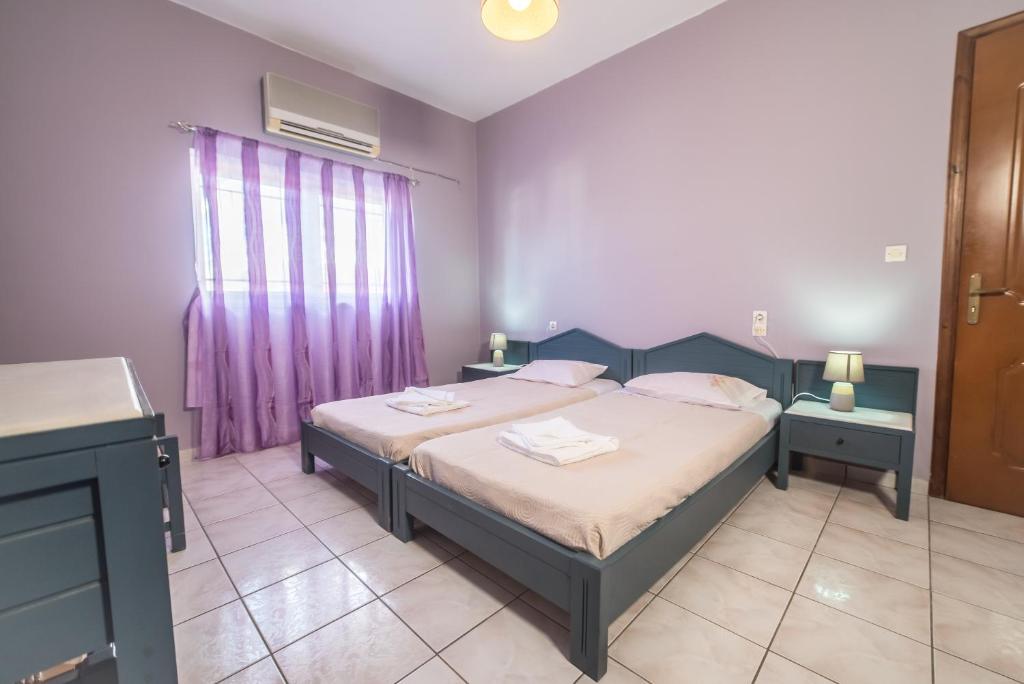 ein Schlafzimmer mit einem Bett und einer lila Wand in der Unterkunft Mamis Studio in Kissamos