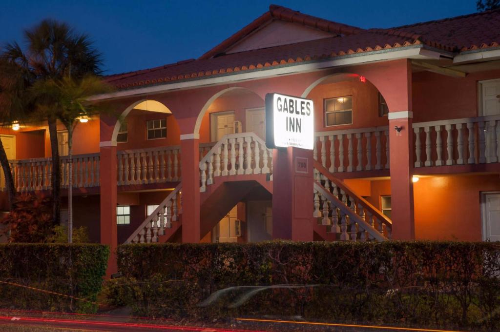 una grande casa con un cartello che legge "Peace Inn" di Gables Inn a Miami
