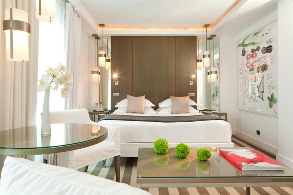 - une chambre avec un lit et une table en verre dans l'établissement Le A, à Paris