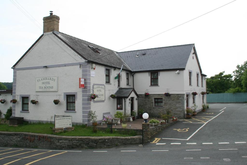 a white building sitting on the side of a street at Flambards Hotel in Cardigan