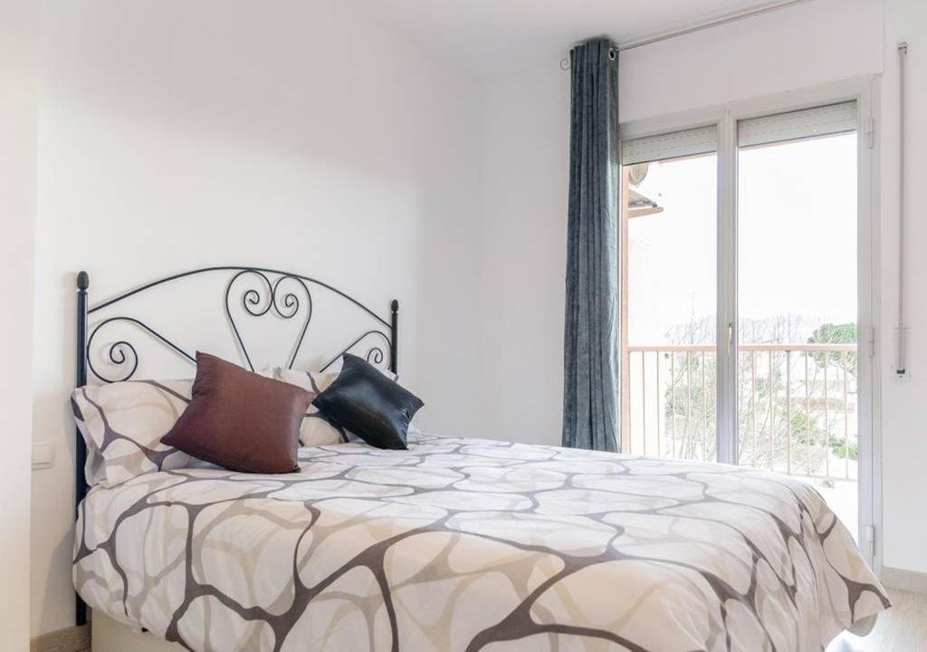 Un dormitorio con una cama grande con almohadas. en Apartamento Dinasty, en Empuriabrava