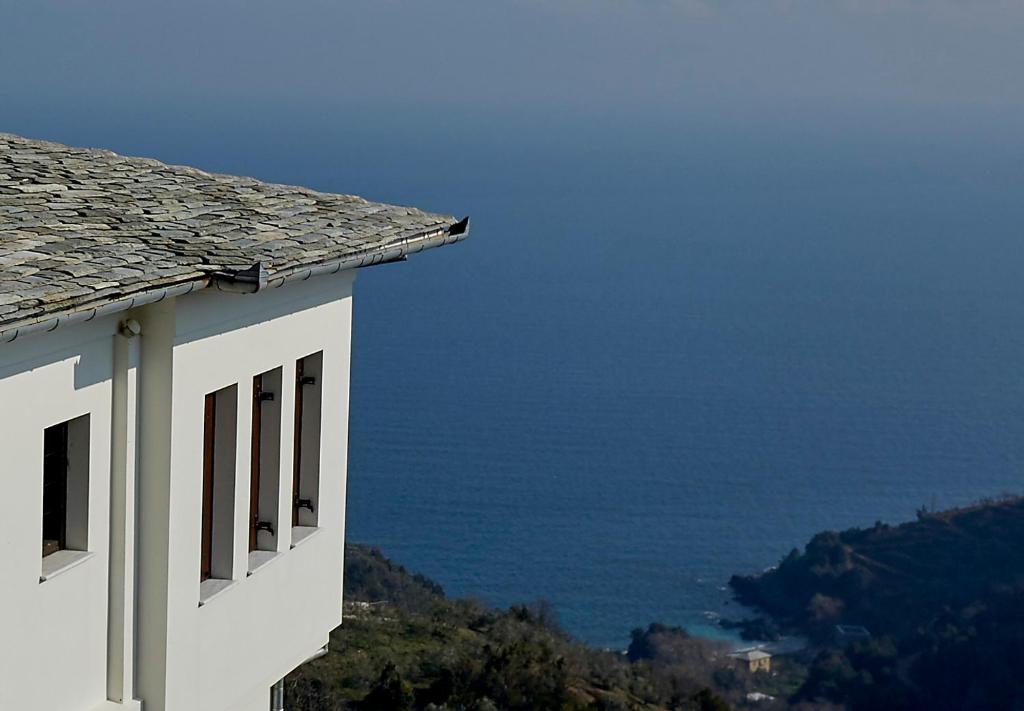 a white building with a view of the ocean at Villa Thea in Makrirrákhi