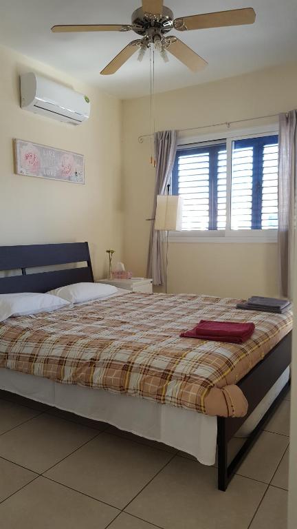 a bedroom with a large bed with a ceiling fan at Efterpis12 St. House in Paralimni