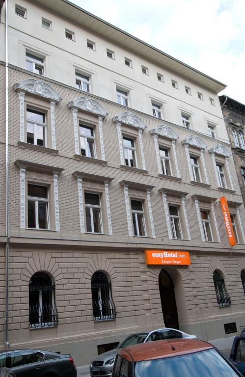 a large brick building with windows on a street at easyHotel Budapest Oktogon in Budapest