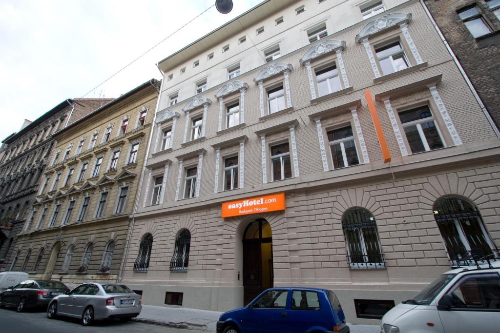 a large building with cars parked in front of it at easyHotel Budapest Oktogon in Budapest
