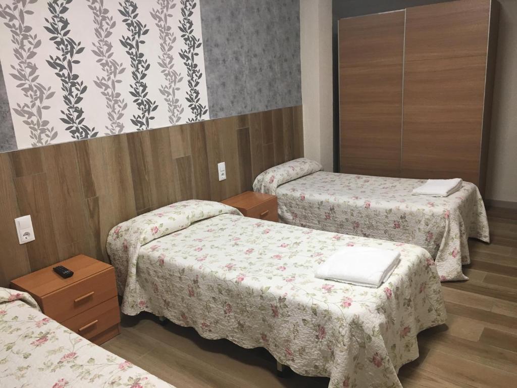 a hospital room with two beds and a mirror at Pensión Blanquita in Logroño