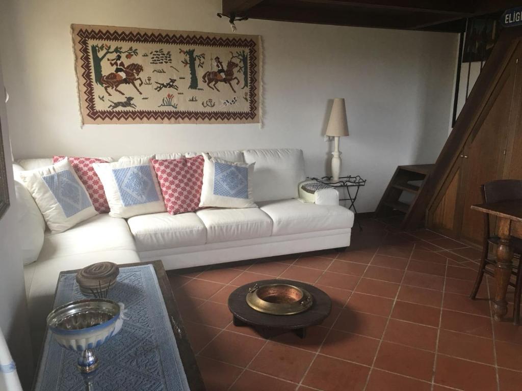 un soggiorno con divano bianco e tavolo di Le Pavoncelle di Stintino a Stintino