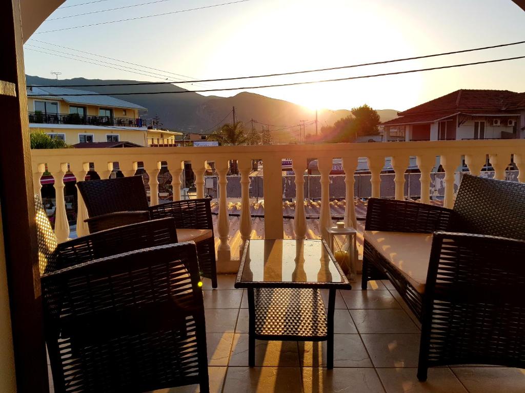 einen Tisch und Stühle auf einem Balkon mit Blick auf den Sonnenuntergang in der Unterkunft Mojo modern apartment in Alikanas