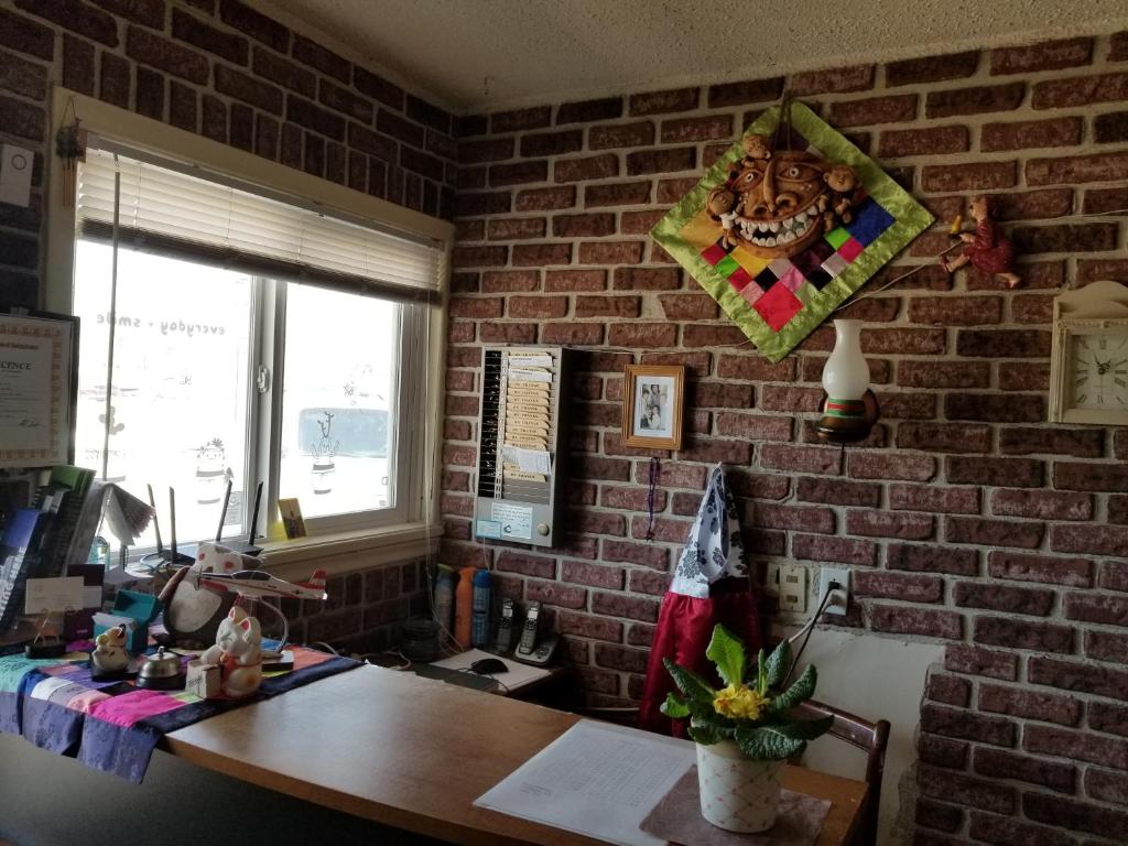 Habitación con pared de ladrillo y escritorio de madera. en Melsask Motel en Melville