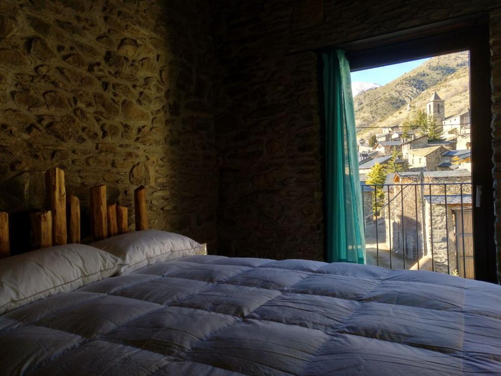 een slaapkamer met een bed en een raam met uitzicht bij Vilamaroto in Meranges