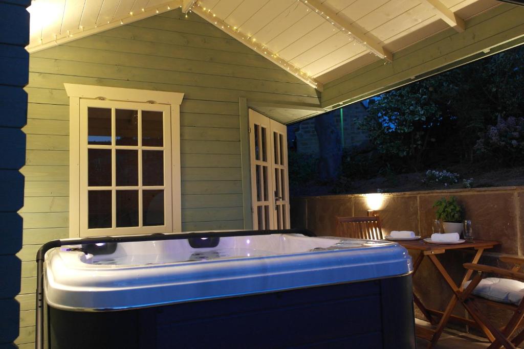 a jacuzzi tub sitting outside of a house at Ashford house 'The Snug' private hot tub in Fylingthorpe