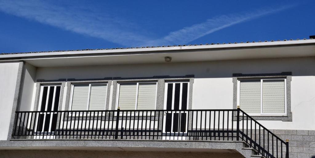 LiresにあるApartamentos casa enriqueの窓付きのバルコニーが備わるホワイトハウスです。