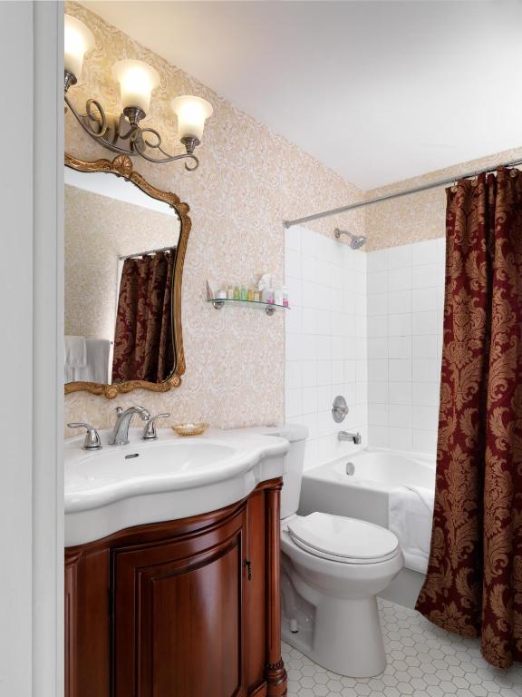 a bathroom with a sink and a toilet and a mirror at Pendray Inn and Tea House in Victoria