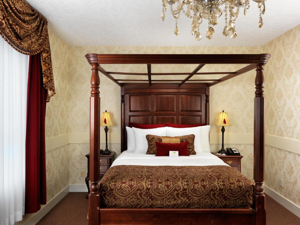 a bedroom with a large bed with red pillows at Pendray Inn and Tea House in Victoria