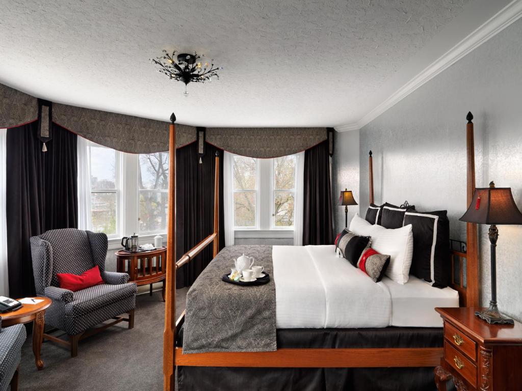 a hotel room with a bed and a chair at Pendray Inn and Tea House in Victoria