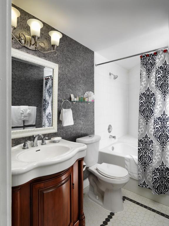a bathroom with a sink and a toilet and a mirror at Pendray Inn and Tea House in Victoria