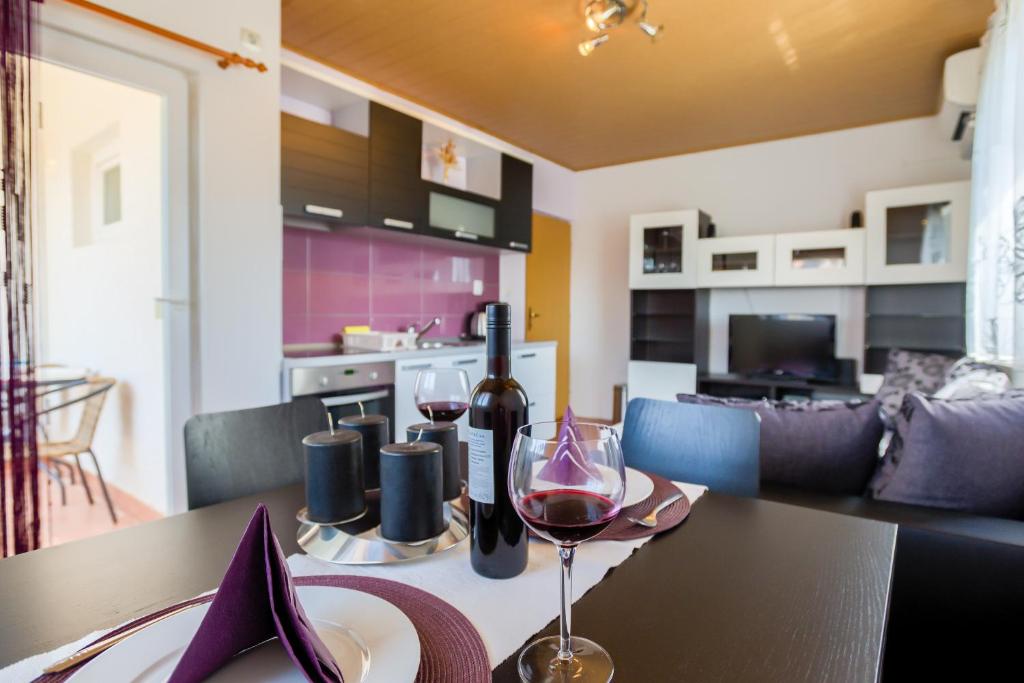 a table with a glass of wine on top of it at Apartment Monica in Ližnjan