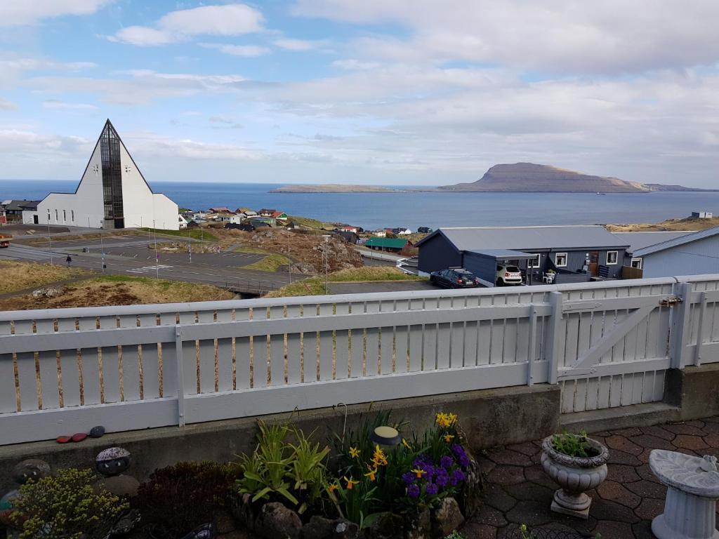 a church with a steeple next to a body of water at Beautiful house in Tórshavn with a great view in Tórshavn