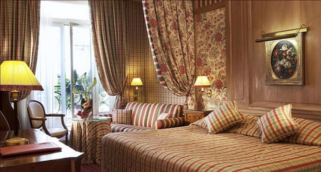 a hotel room with a bed and a couch at Chambiges Elysées in Paris