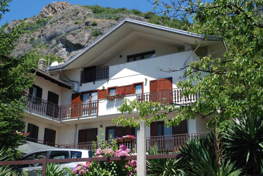 una casa con una montagna sullo sfondo di Hotel Le Verger a Châtillon