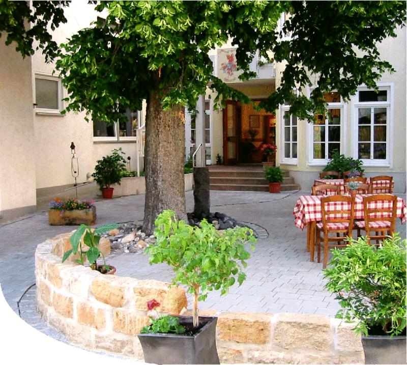 a table and chairs and a tree in front of a building at Zur schönen Schnitterin in Bad Staffelstein