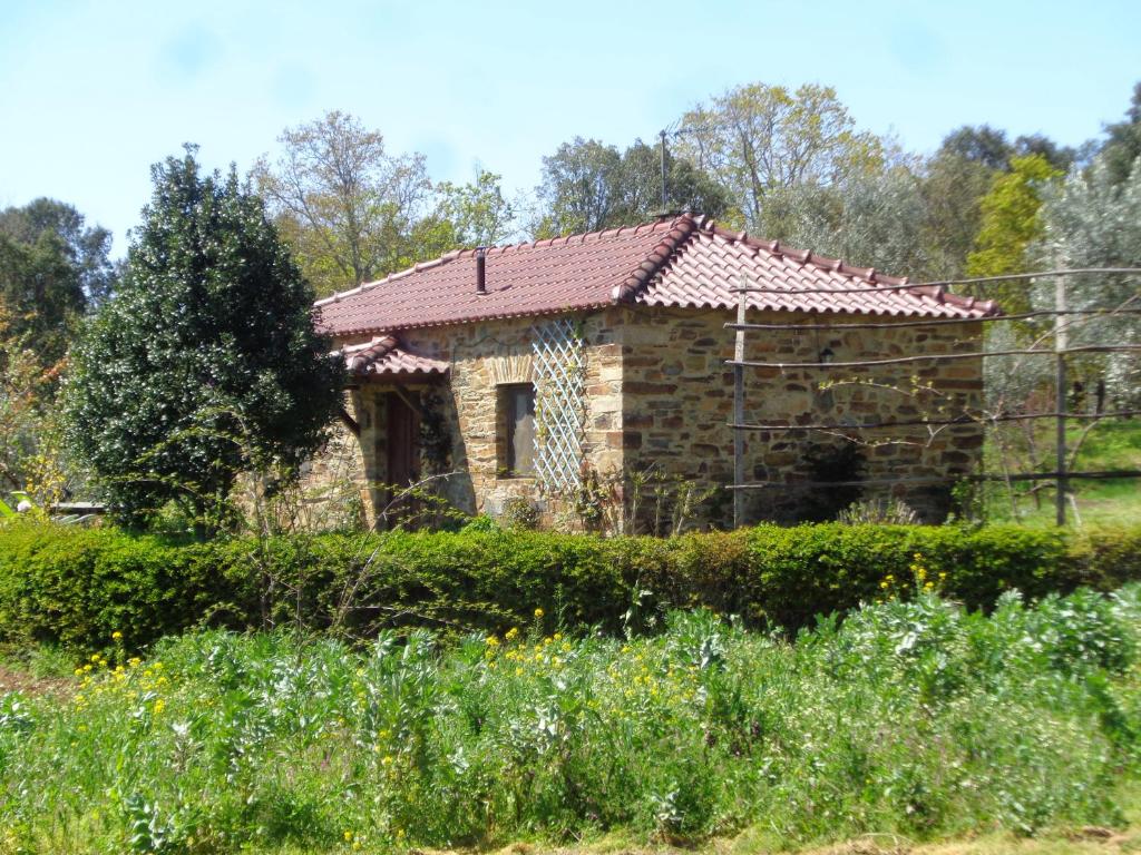 una antigua casa de piedra con techo de baldosa en Casa do Retiro, en Pedrógão Grande