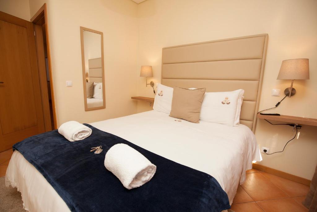 a hotel room with a large bed with towels on it at ML Formosa Deluxe Rooms in Porto