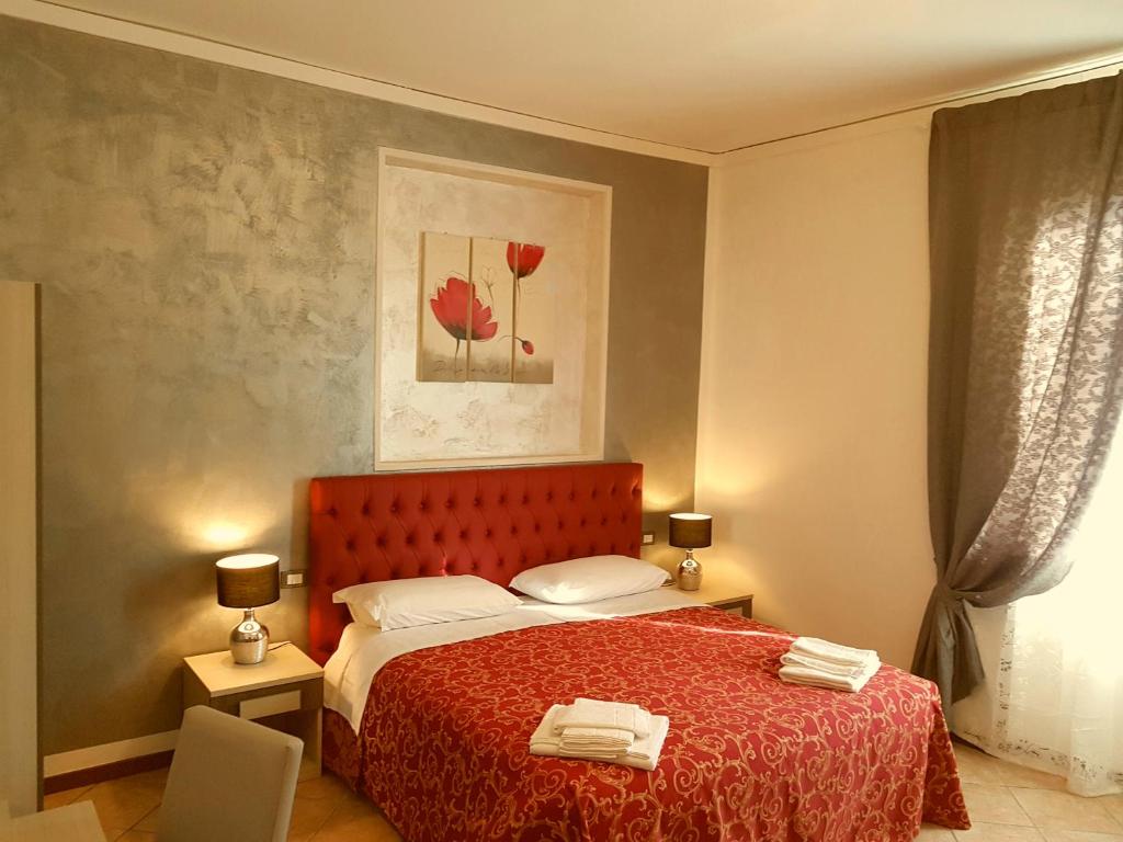 a bedroom with a bed with a red bedspread at B&B La Cittadella in Florence