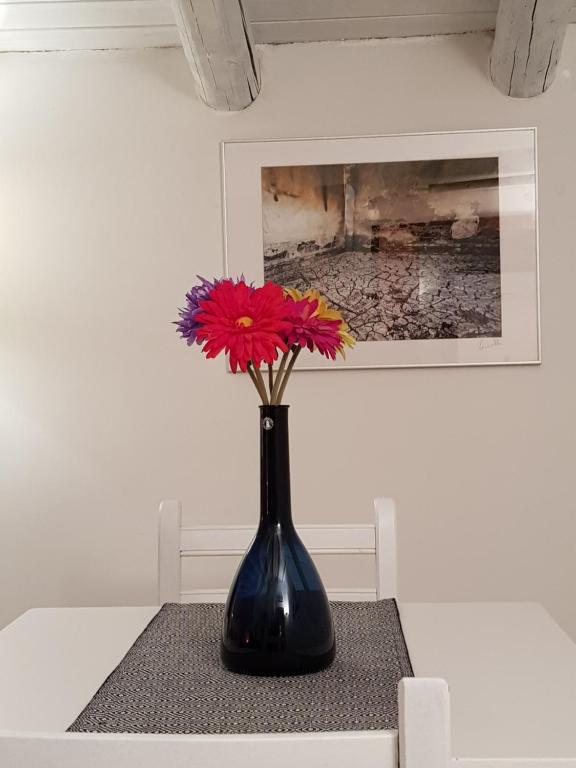カターニアにあるCaronda Apartmentsのテーブルの上に花の入った黒い花瓶