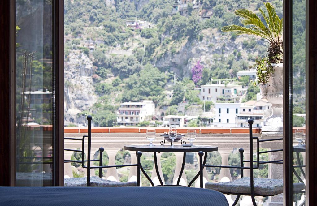
a dining room table with a balcony overlooking a city at Villa Palumbo B&B in Positano
