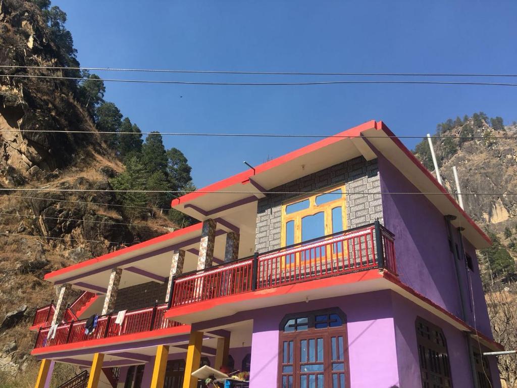 a colorful house on top of a mountain at Snow View Guest House in Kasol